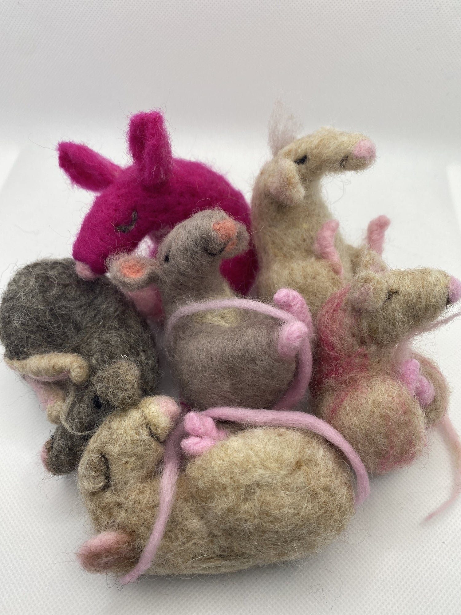 Collection of felted sleepy support mice on a white background